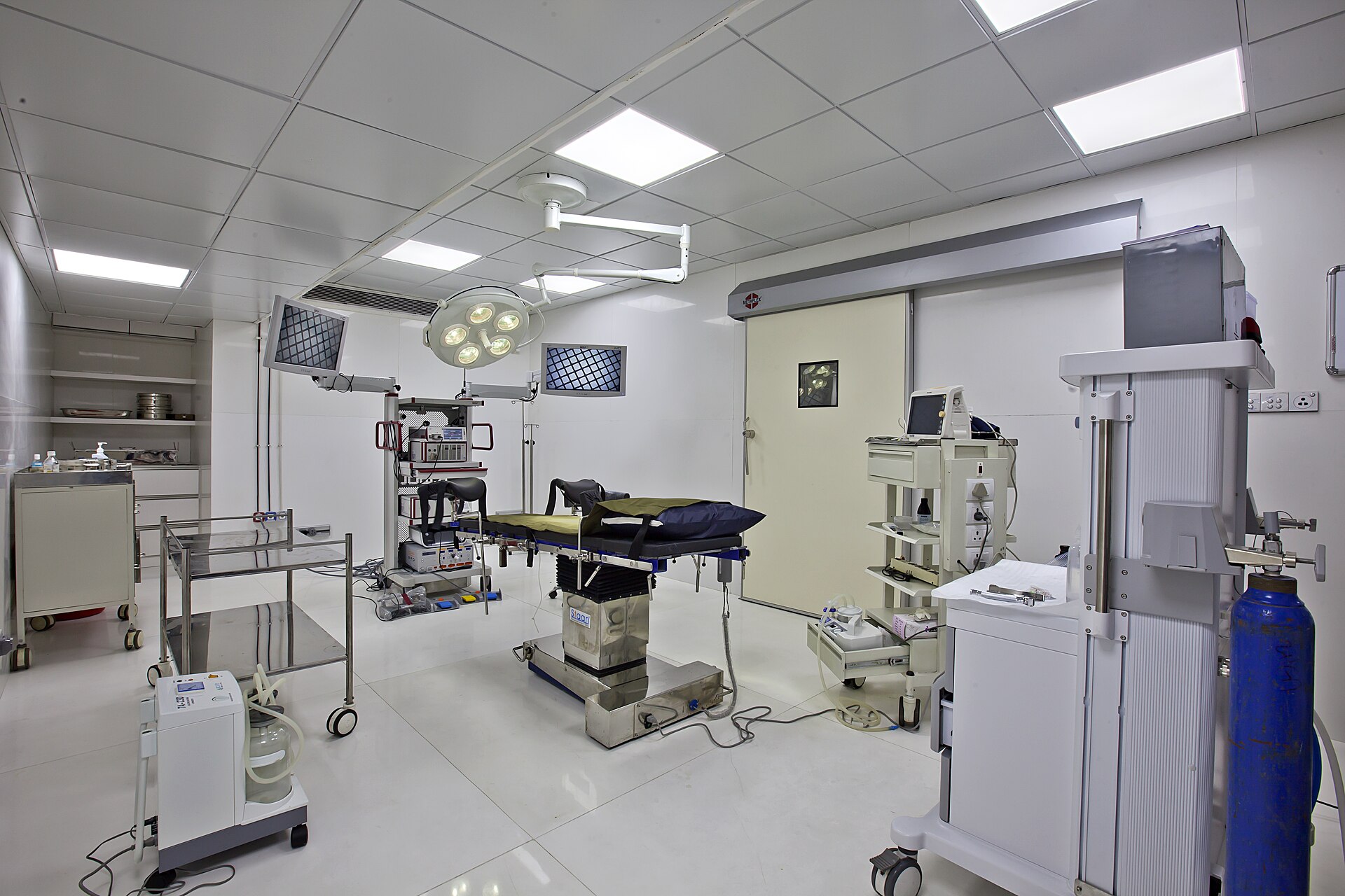 A surgical team at work under theatre lights during a laparoscopic operation