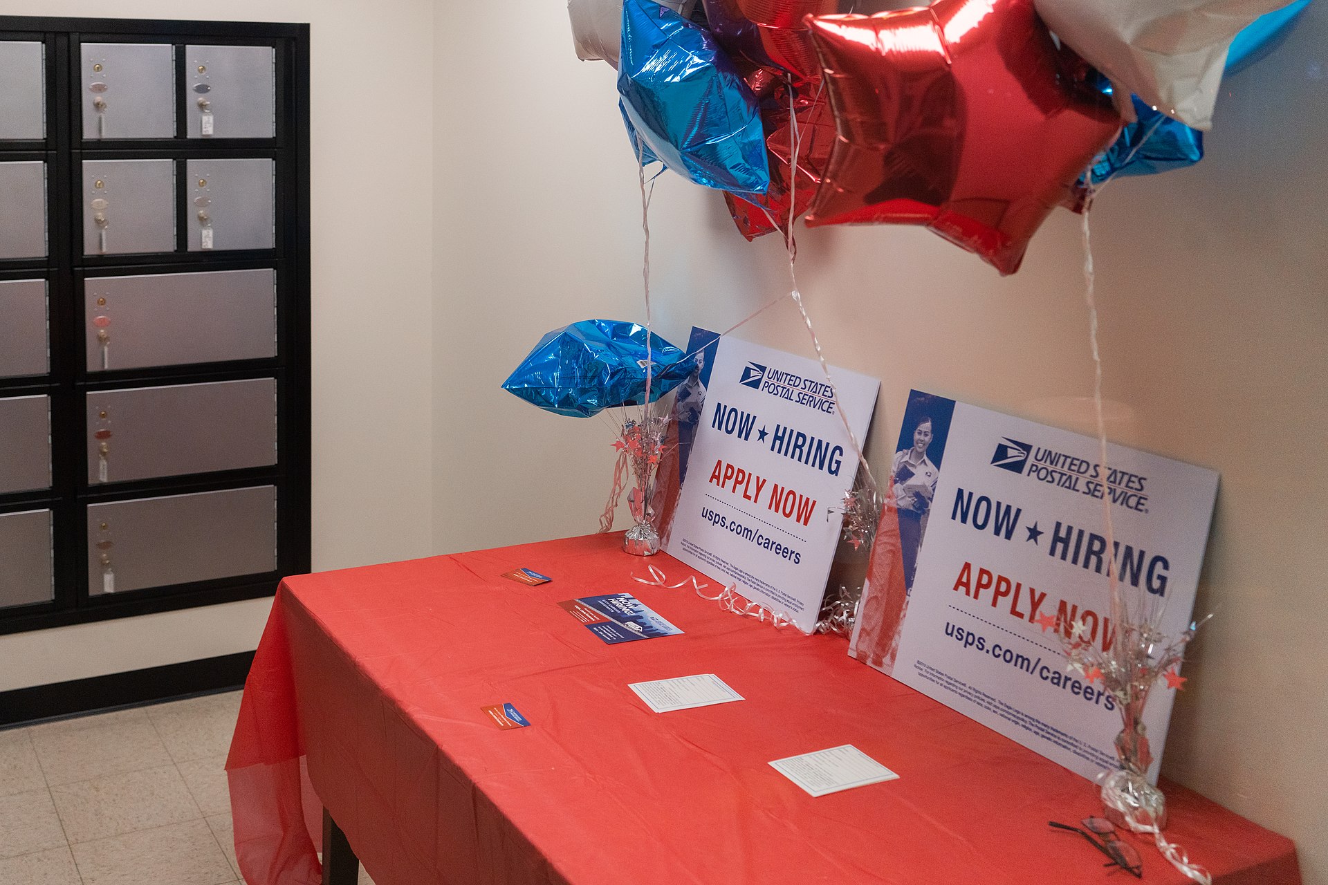 Now-hiring signs taped in the window of a temporary post office in Minneapolis